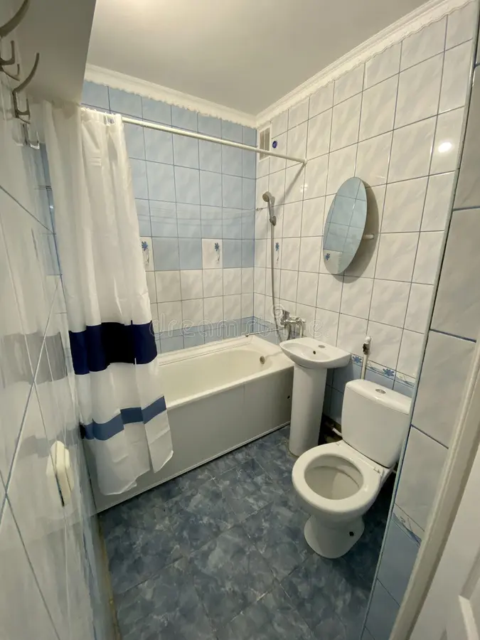 Koude en kille badkamer met verouderde betegeling